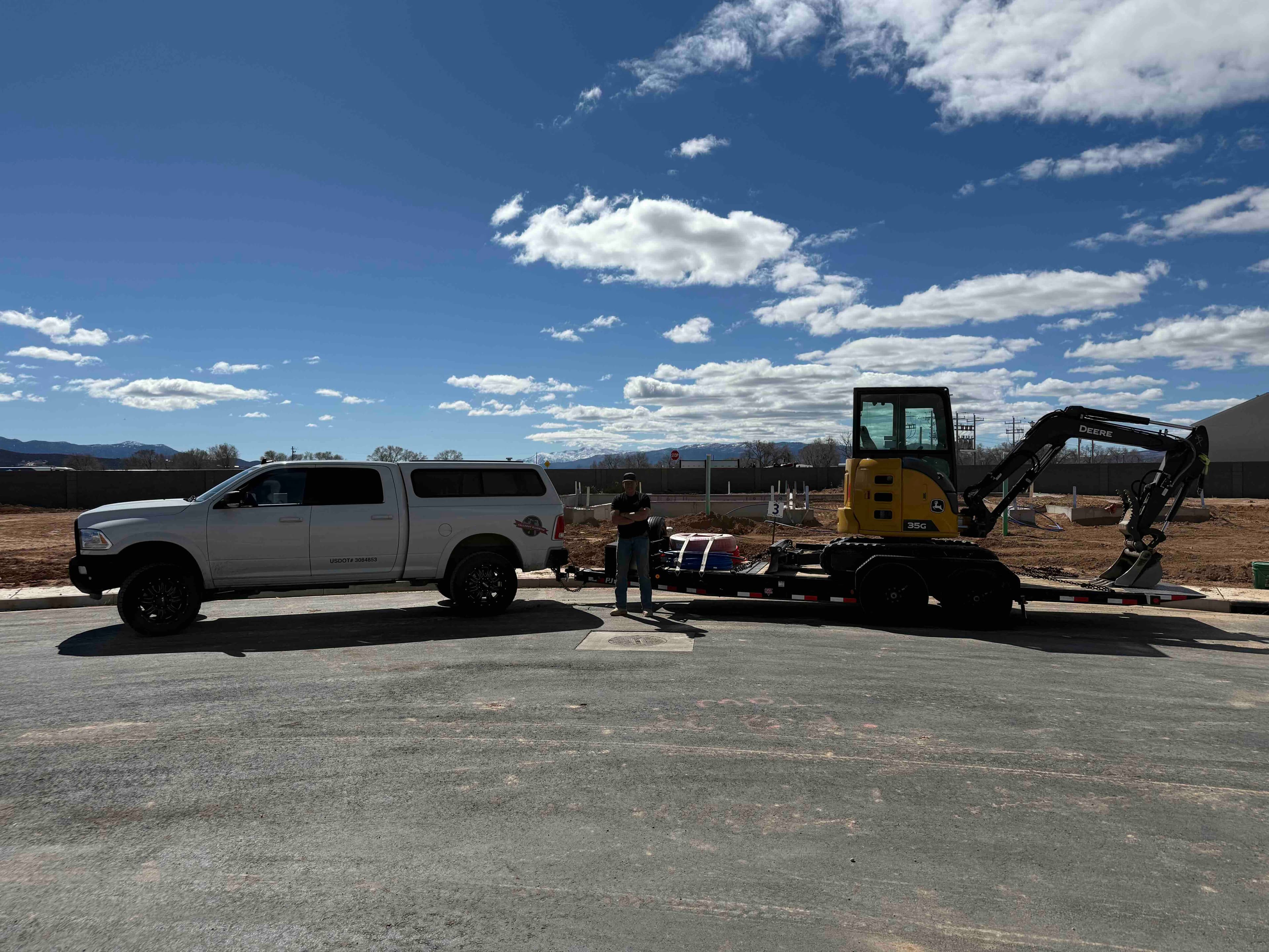Halladay Plumbing truck and excavator staged at a new construction job site in Cedar City, UT